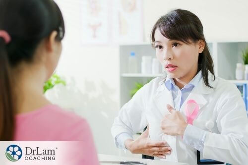 An image of a female doctor showing a patient what to do to examine her breasts